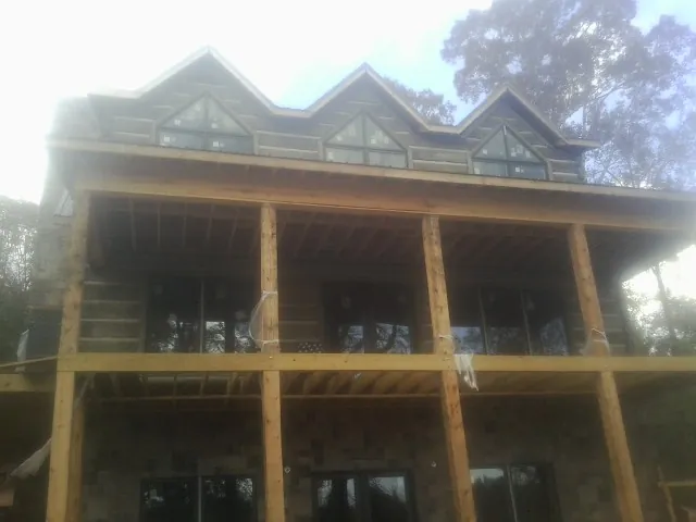 Dormers and porch framing on a large log home under construction — Roof Coating work by our crew in Divide